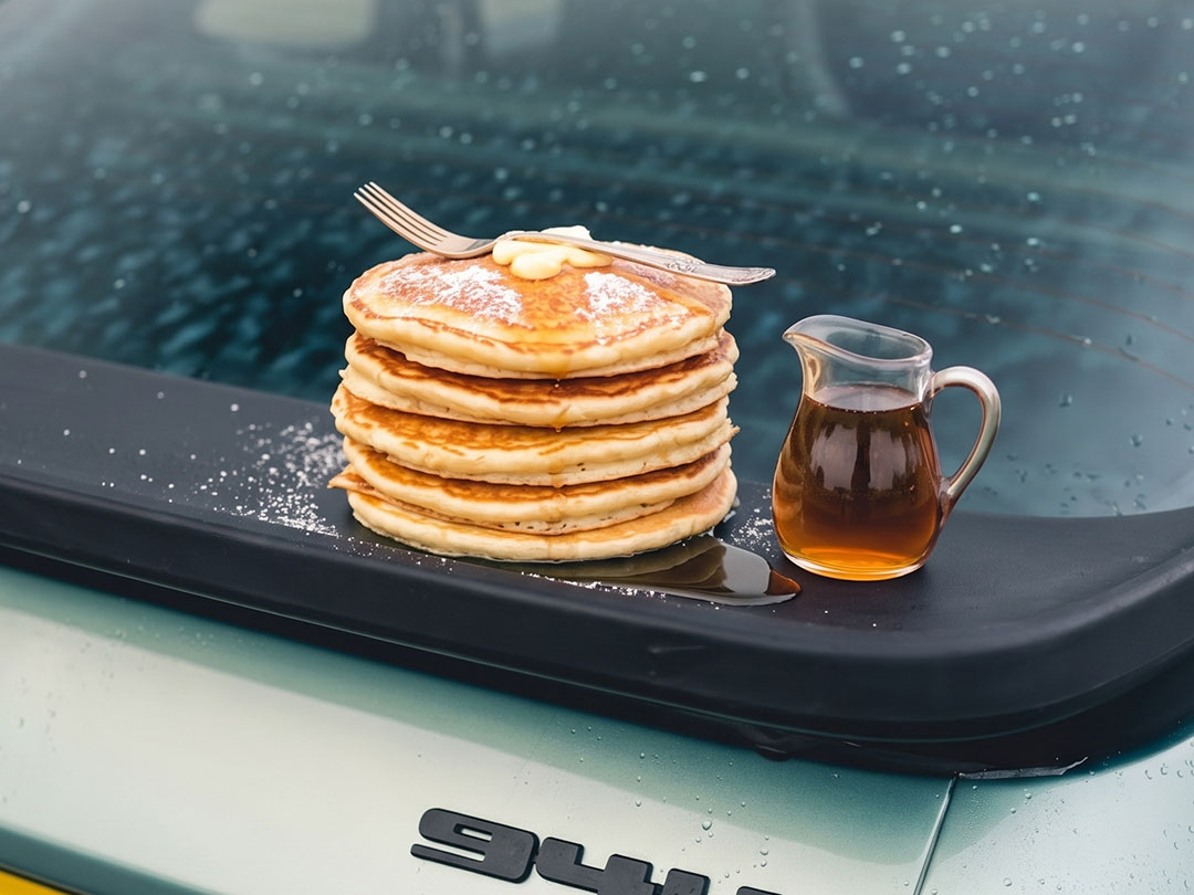 Pancakes on a paper plate, syrup bottles lined up