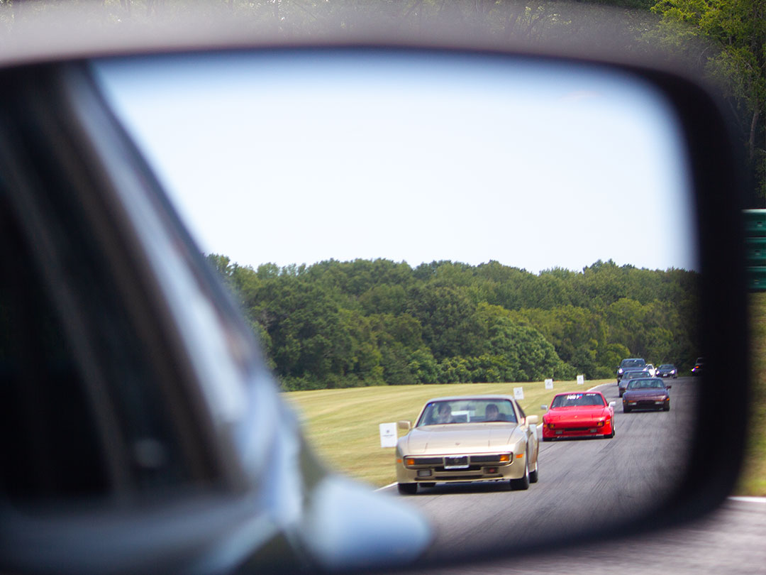 Long line of cars on the VIR main straight during a parade lap